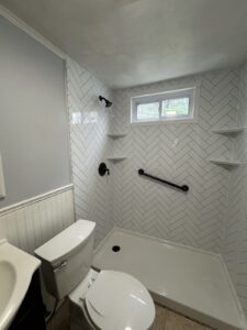 white walk in shower with grab bar